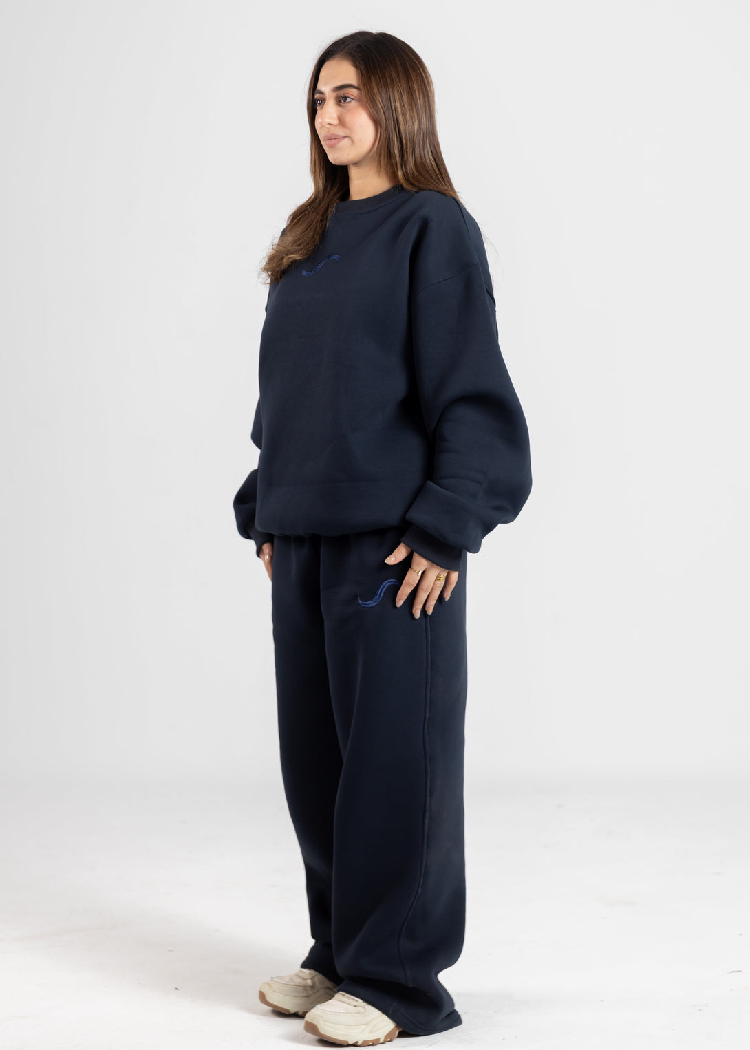 Person wearing a navy blue outfit on a white background