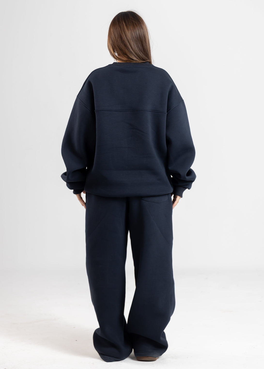 Person wearing a navy blue outfit on a white background